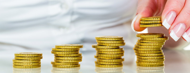 Ein Bild auf dem 4 verschiedene Münzstapel gestapelt wurden. Am letzten Stapel ist eine Hand zu sehen die gerade 3 Münzen auf den letzten Stapel setzt.