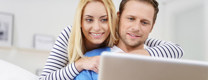 Ein Pärchen das in einen Laptop schaut