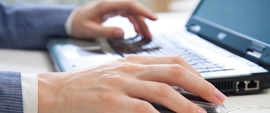 Ein Bild auf dem ein PC und eine Hand zu sehen ist