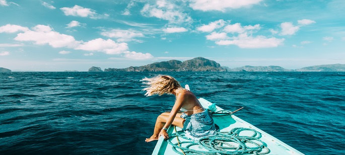 Ein Bild auf dem Wasser wo eine Frau auf einem Boot sitzt