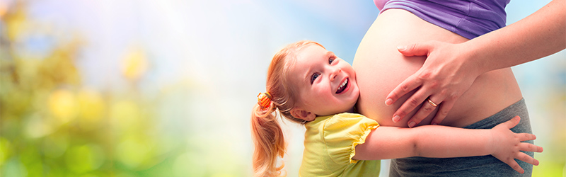 Ein Bild mit einer Schwangeren Frau und ein Kind umarmt diesen Schwangerschafts Bauch