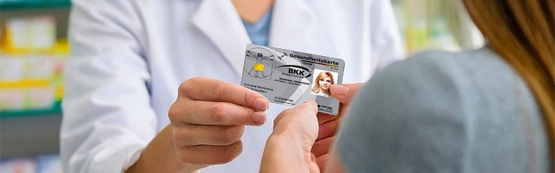 Ein Bild auf dem ein Arzt einer Frau die Gesundheitskarte überreicht